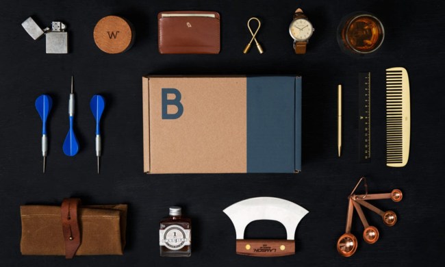 A Bespoke box in the middle of a black table, surrounded by various items.