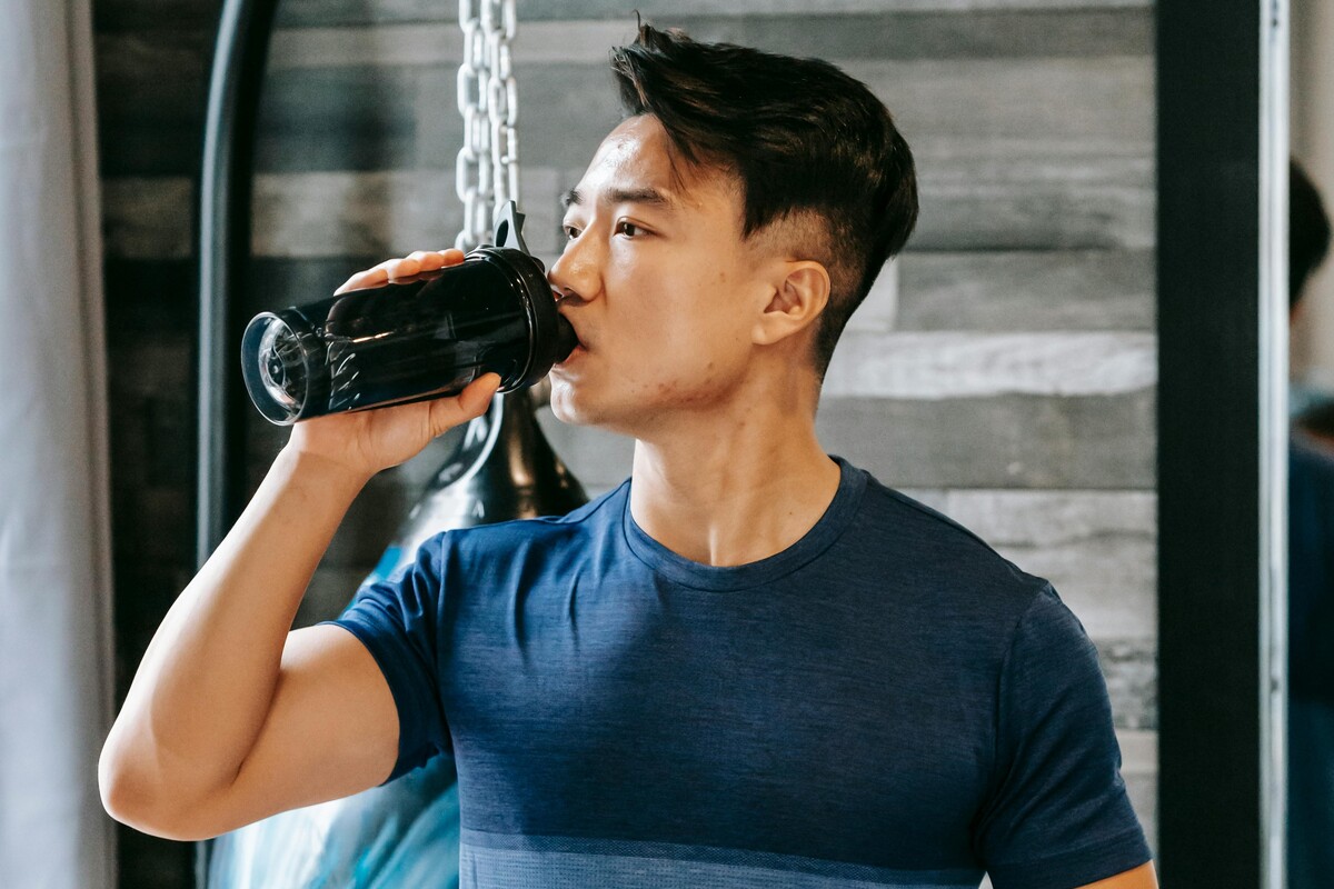 Man drinking from shaker bottle.