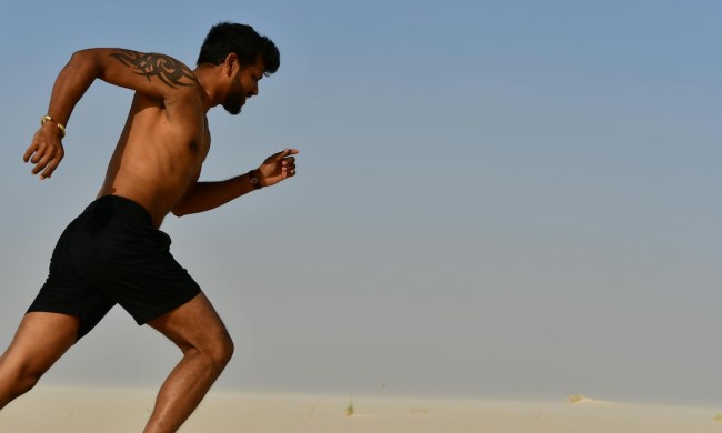 a close up of a shirtless man running outside