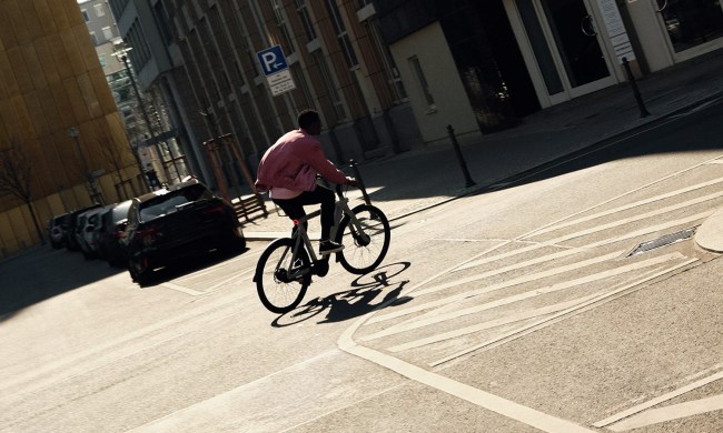 Man riding through city streets on a VanMoof electric bike/ebike.